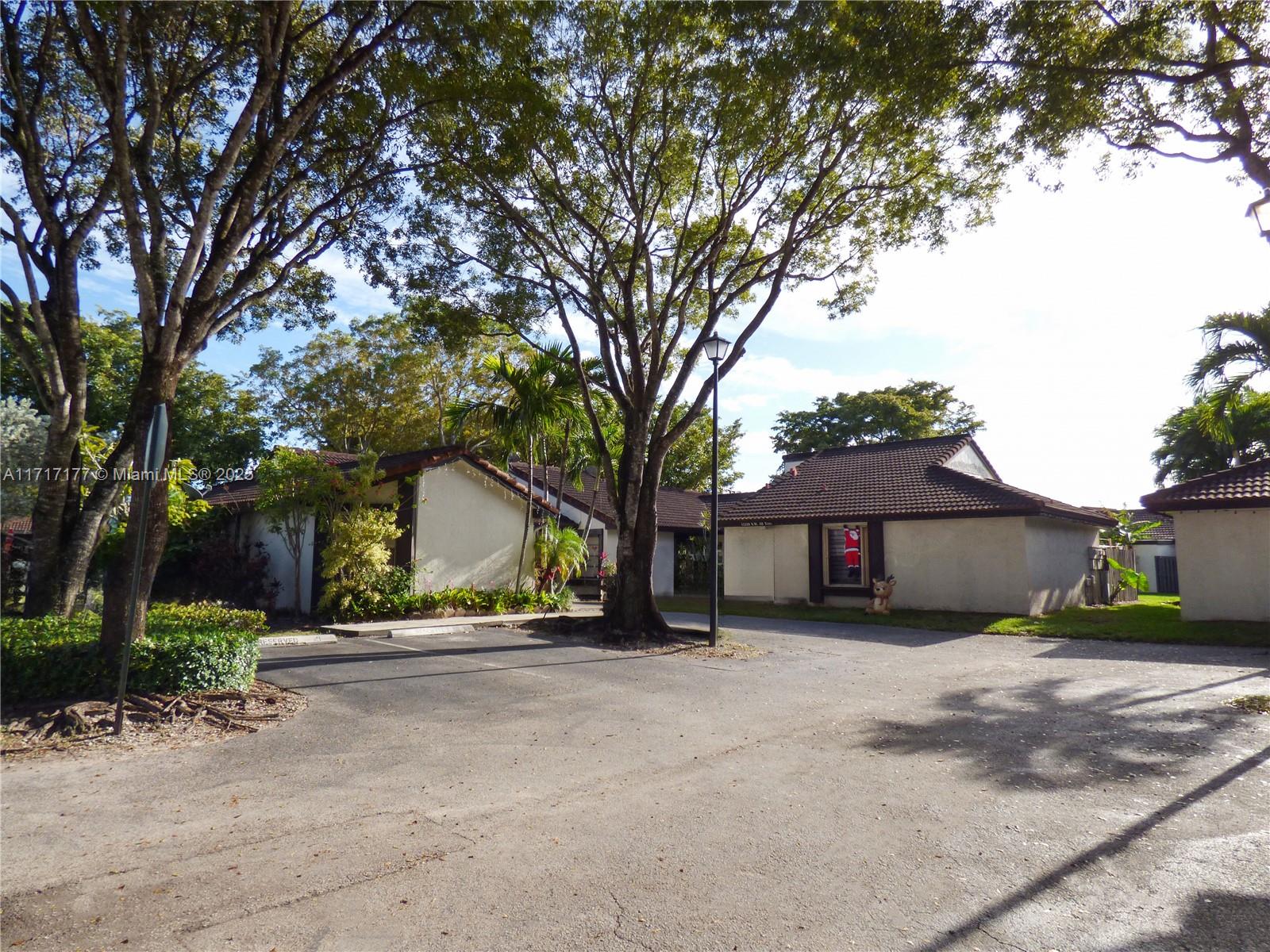 a view of a house with a yard and large tree