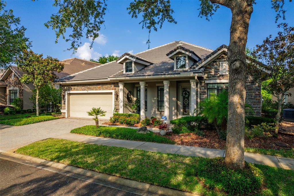 a front view of a house with a yard and potted plants