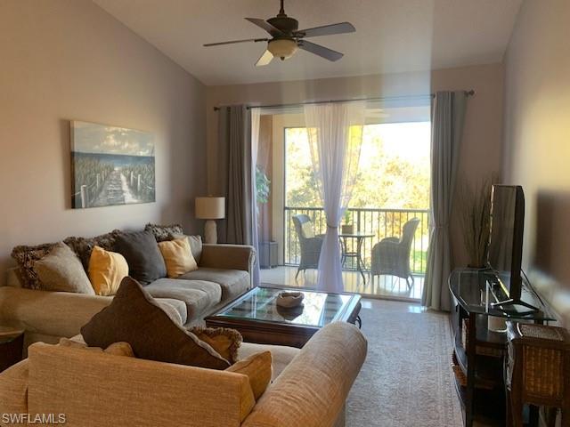 a living room with furniture a ceiling fan and a flat screen tv