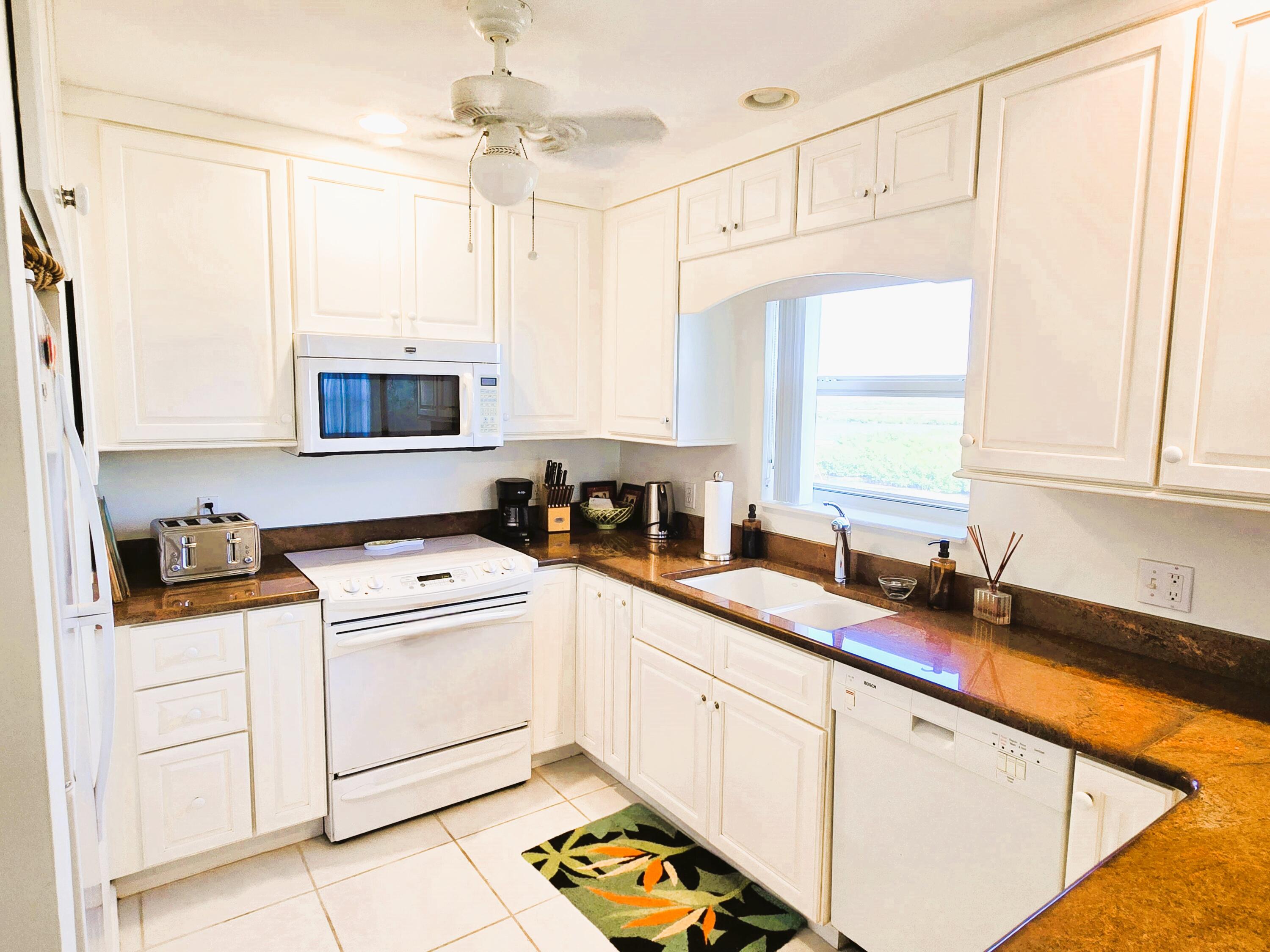 a kitchen with cabinets appliances a sink and a window