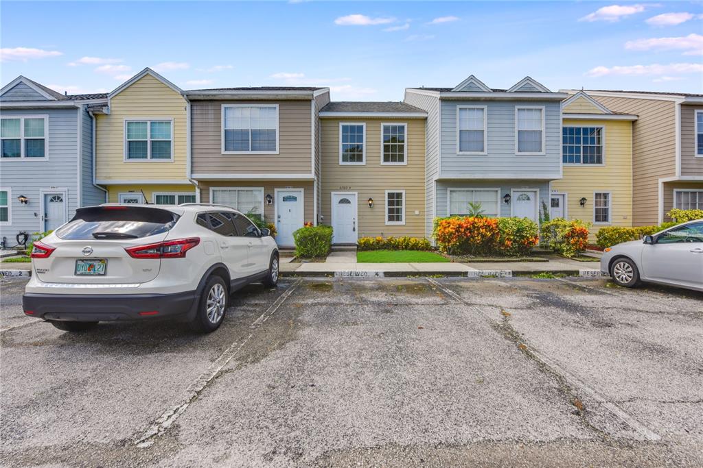 a front view of a house with cars parked