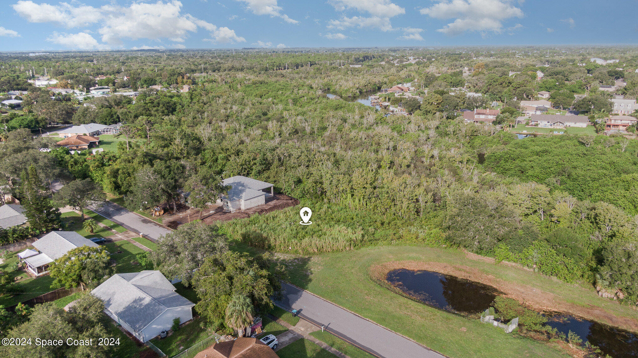 an aerial view of residential houses with outdoor space and trees