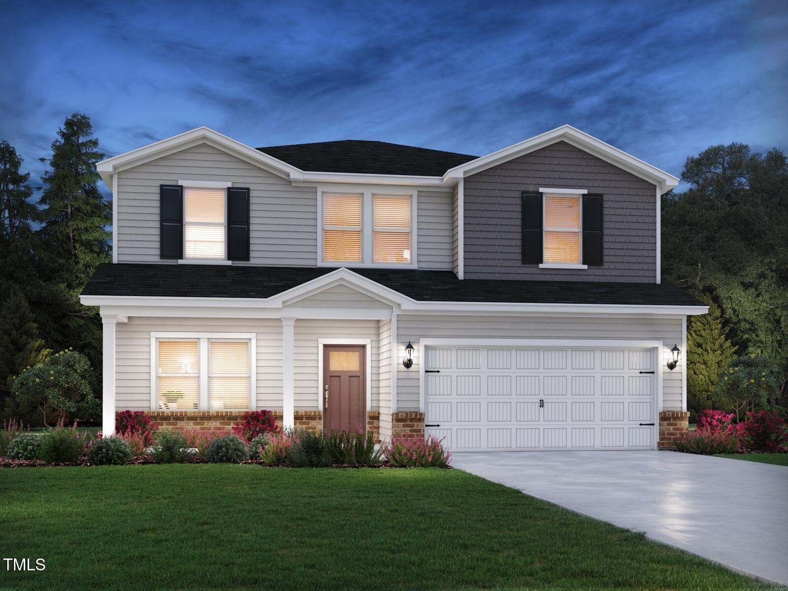 a front view of a house with a garden and yard