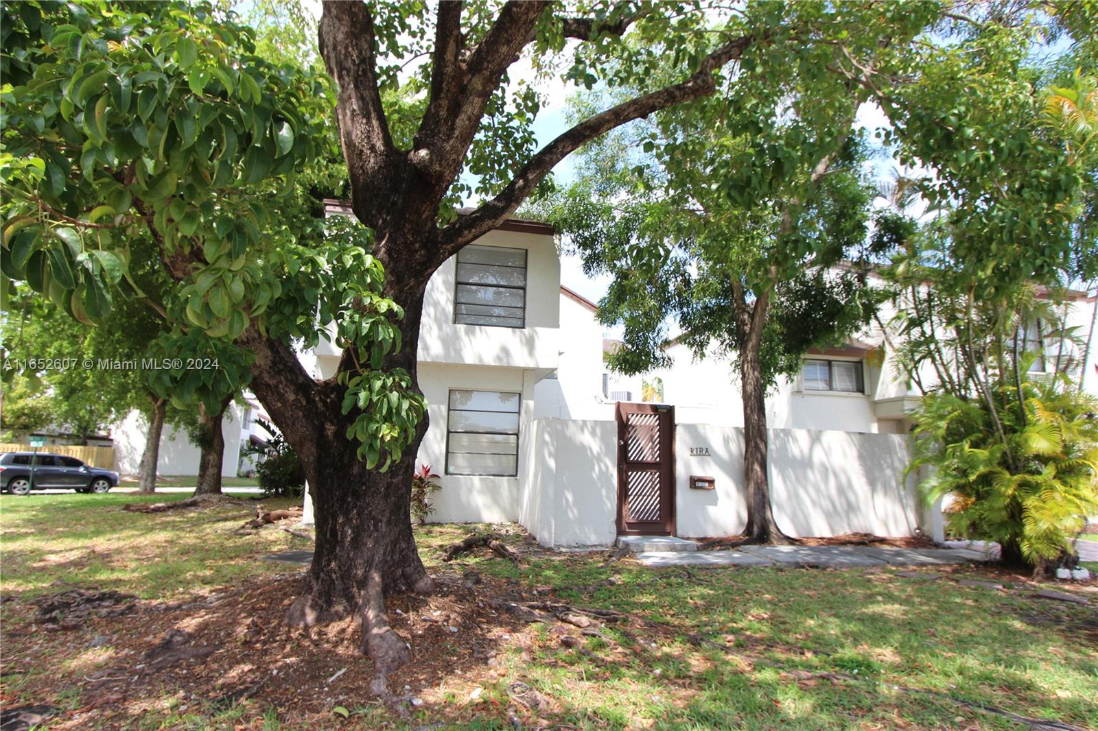 a white house that has a tree in front of the house