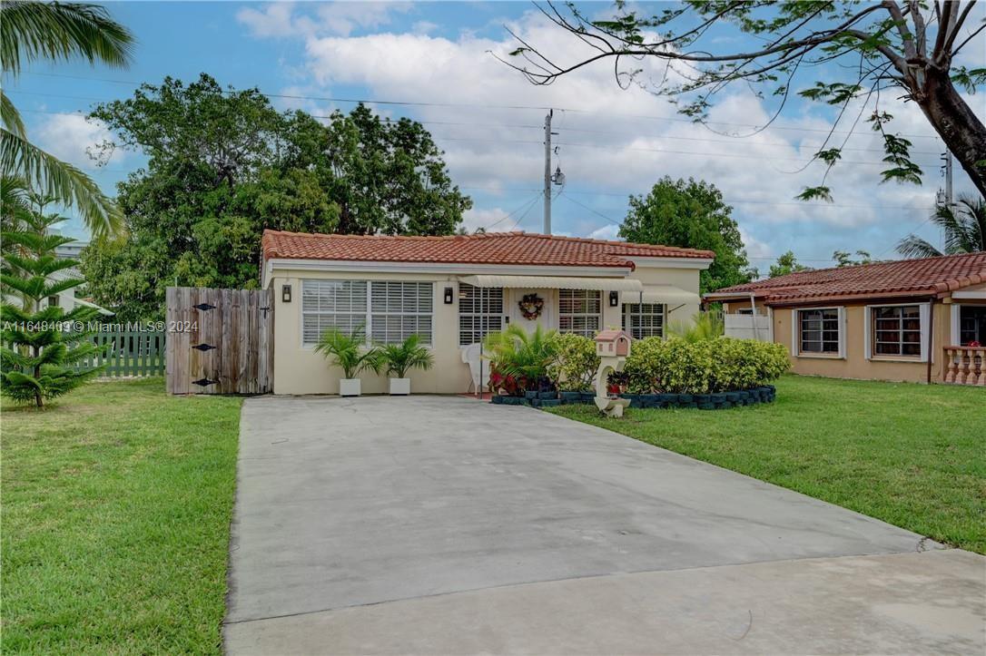 a front view of a house with a garden and yard