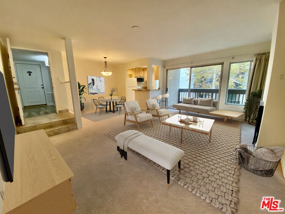 a living room with furniture and a floor to ceiling window