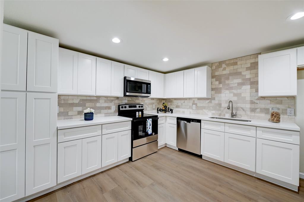 a kitchen with white cabinets stainless steel appliances and sink