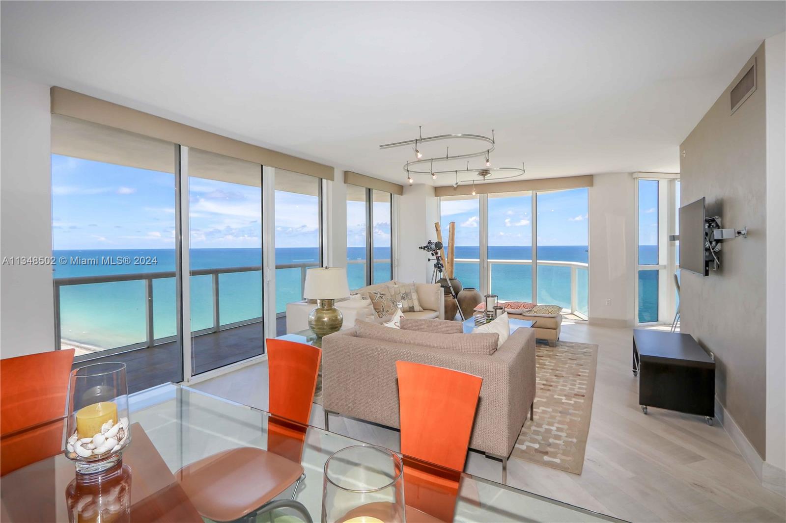 a living room with furniture a flat screen tv and a large window