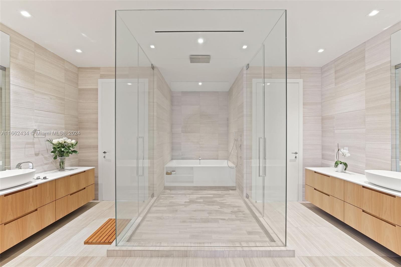 a bathroom with a tub a sink and a large mirror