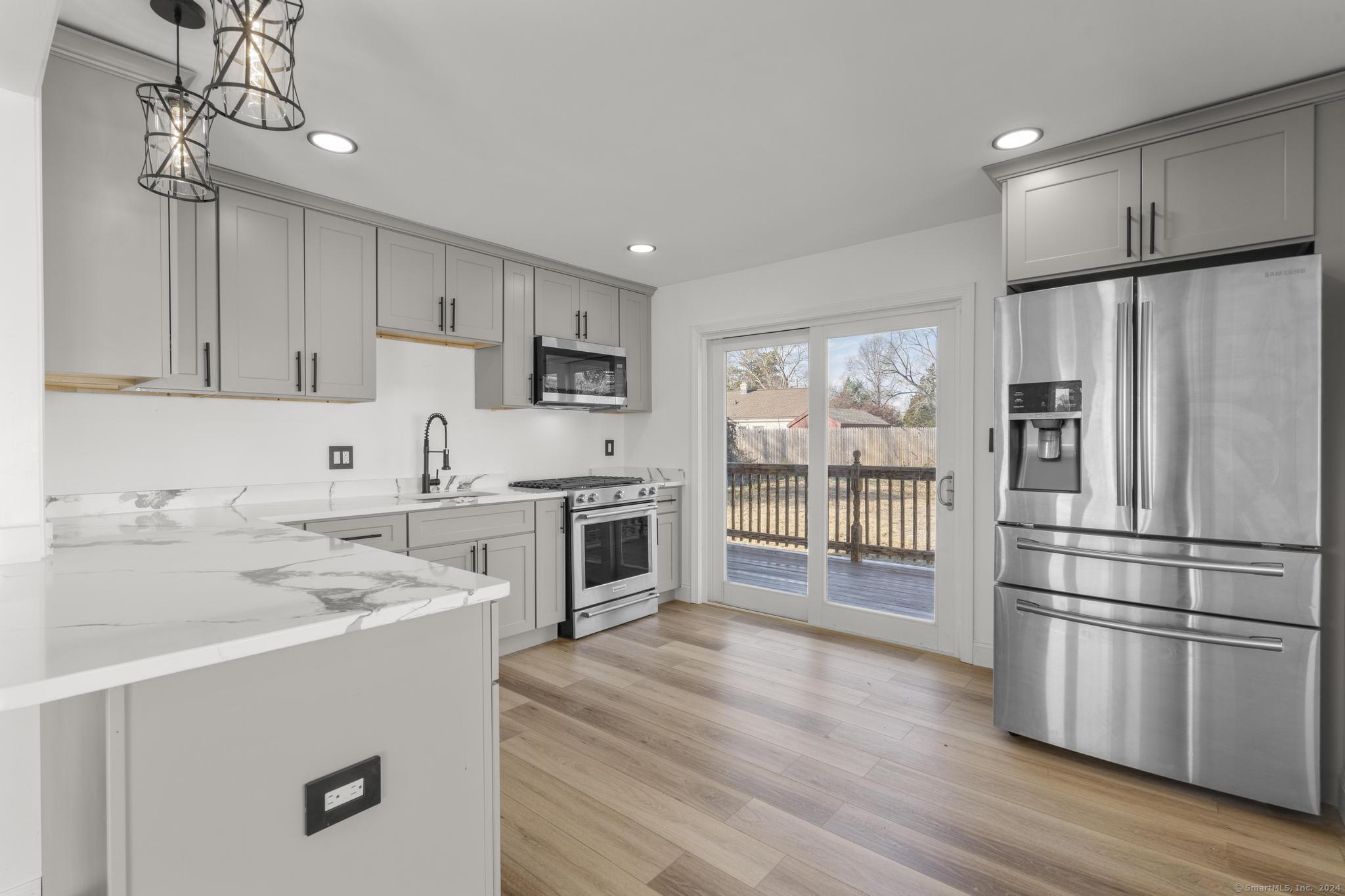 Beautiful view of the deck from the kitchen, Quartz countertops, new cabinets, stainless steel appliances, vinyl flooring, modern finishes