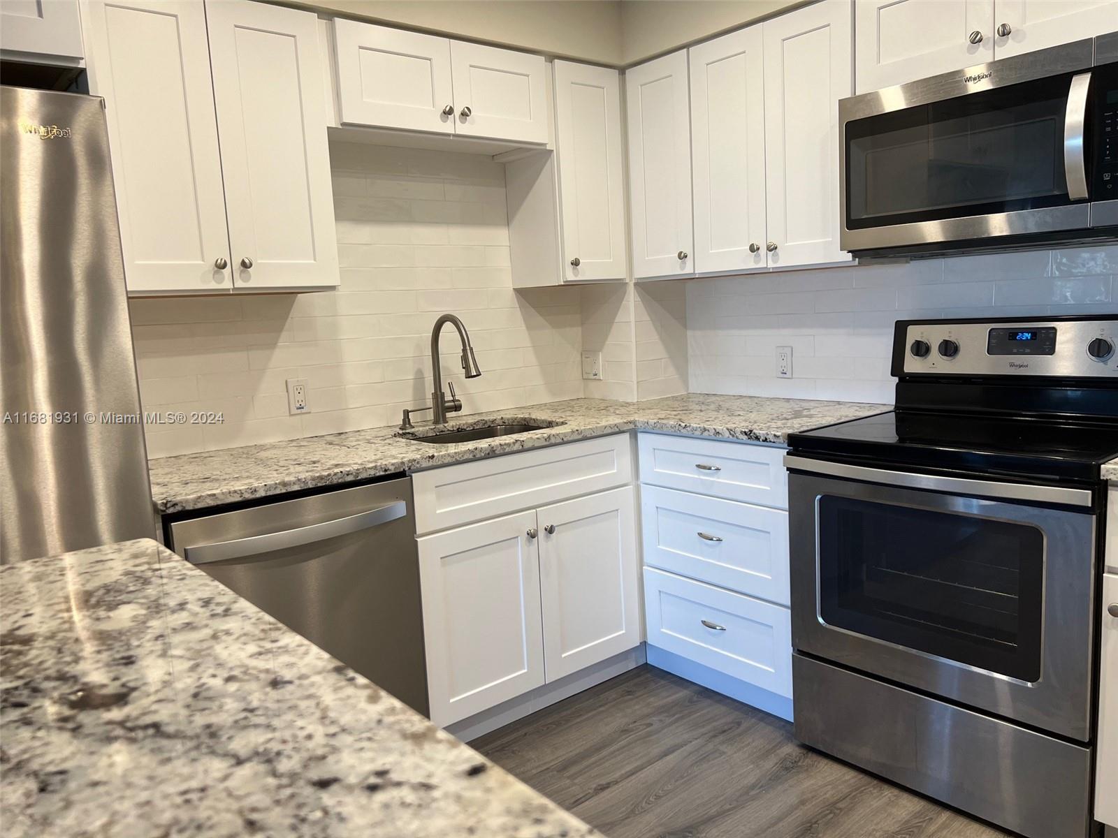 a kitchen with stainless steel appliances granite countertop a stove microwave and sink