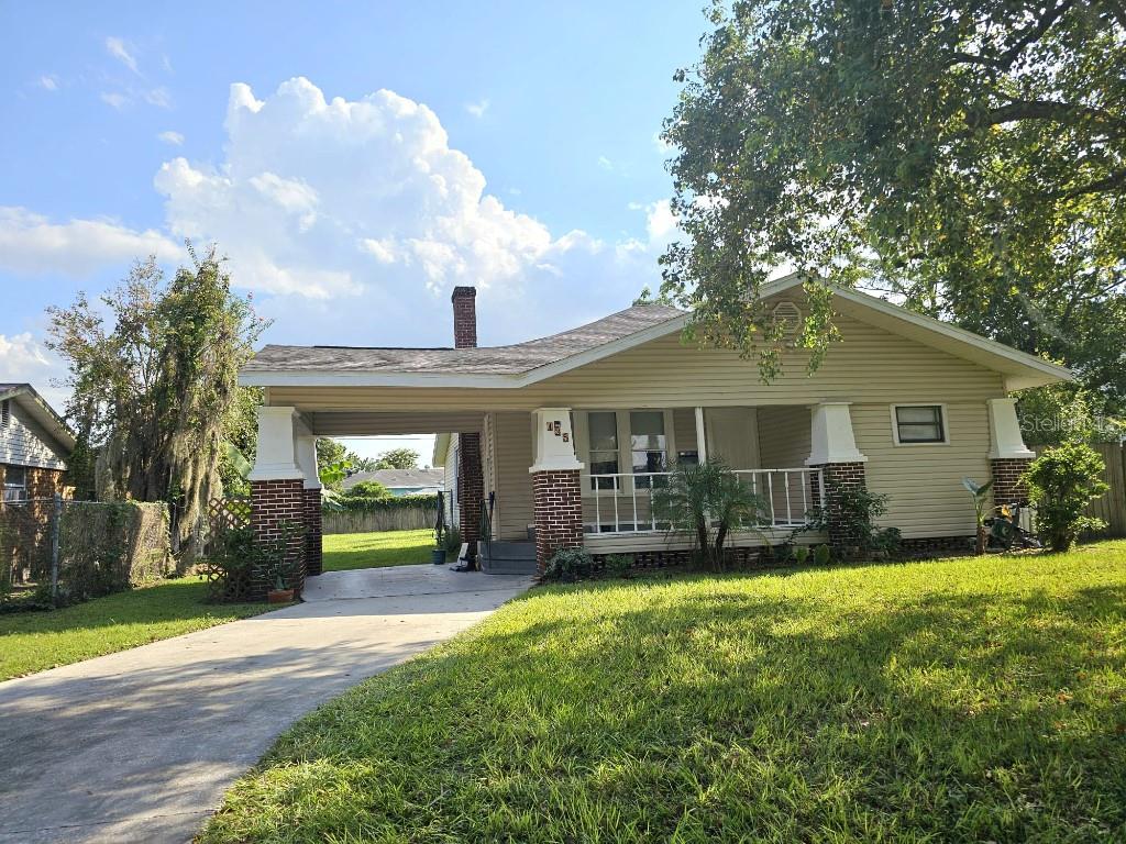 a view of a house with a yard and sitting area