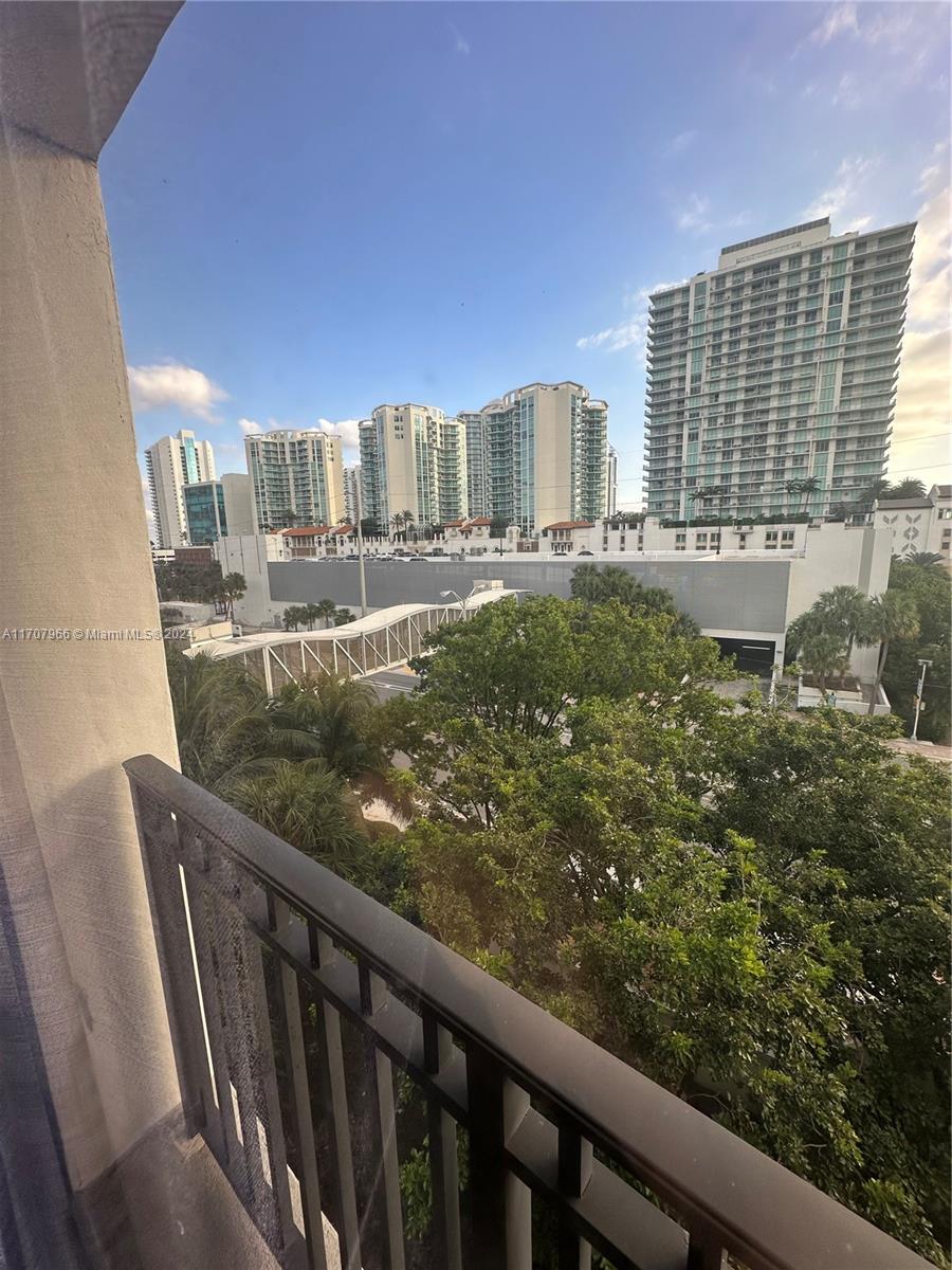 a view of balcony with a couple of cars parked in garage