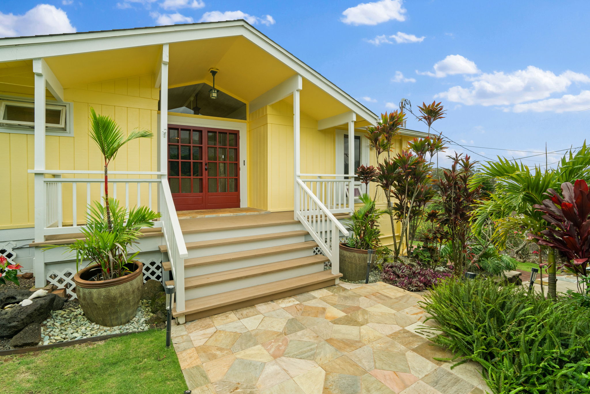 a yellow house with swimming pool in front of it