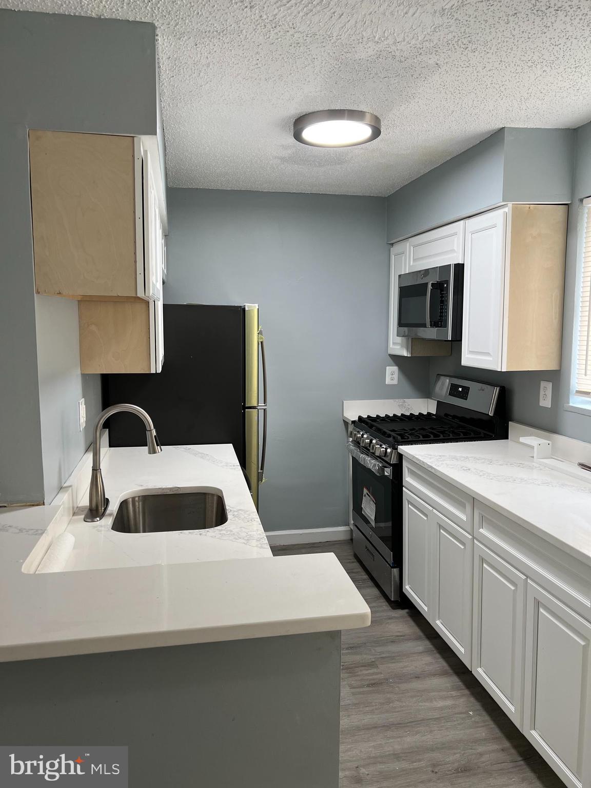 a kitchen with a sink dishwasher a stove and a microwave oven on the kitchen countertops