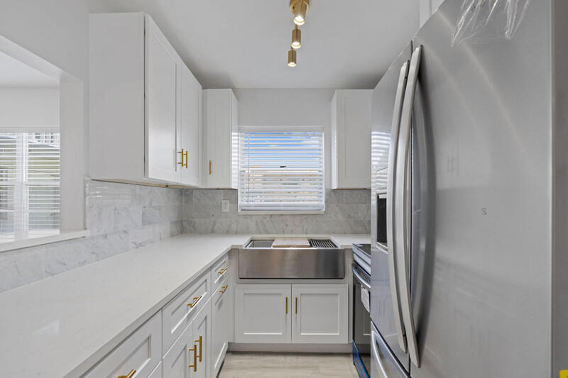 a kitchen with stainless steel appliances a sink stove and refrigerator