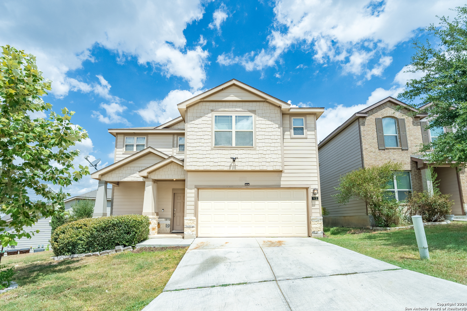 a front view of a house with a yard and garage