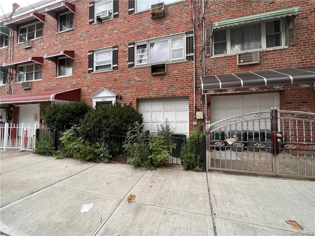 View of property featuring a garage, an AC wall unit, and cooling unit