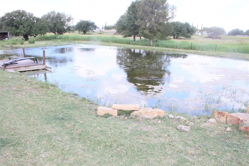 a view of a lake with a yard and outdoor seating