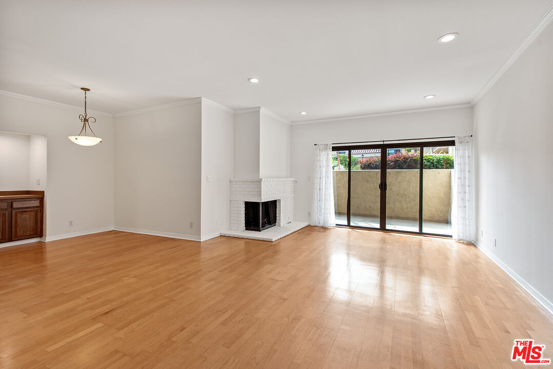 a view of an empty room with a fireplace and a window