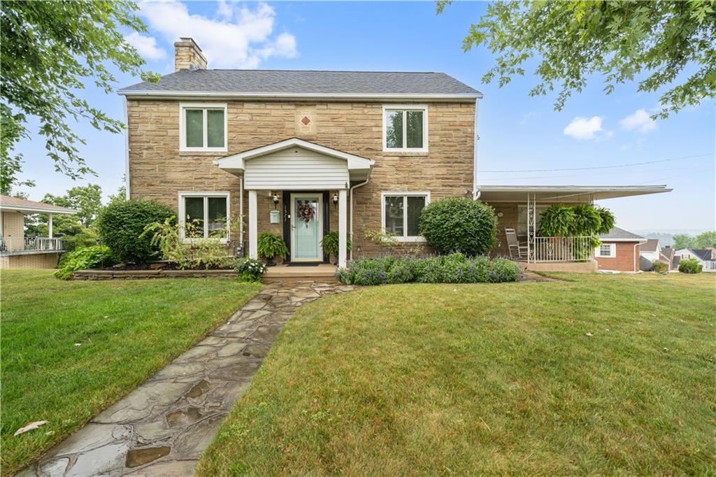 a front view of a house with a yard and potted plants