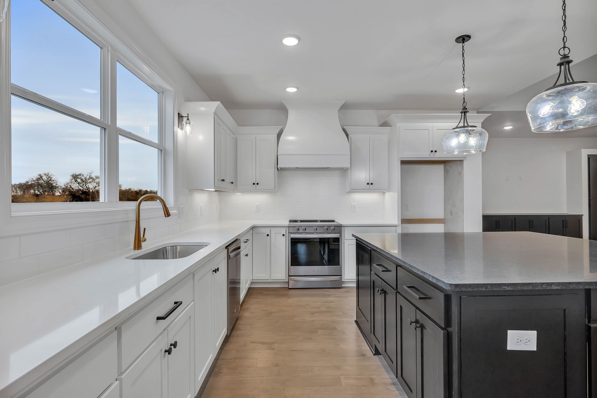 a kitchen with stainless steel appliances granite countertop a sink a stove and a refrigerator