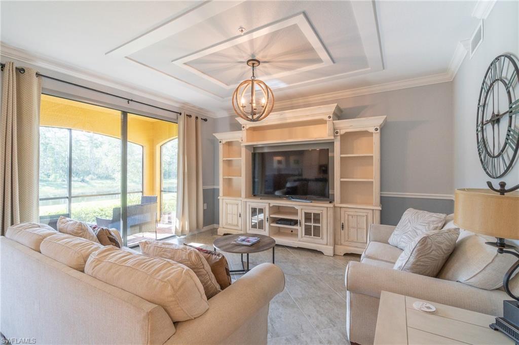 a living room with furniture a flat screen tv and a large window