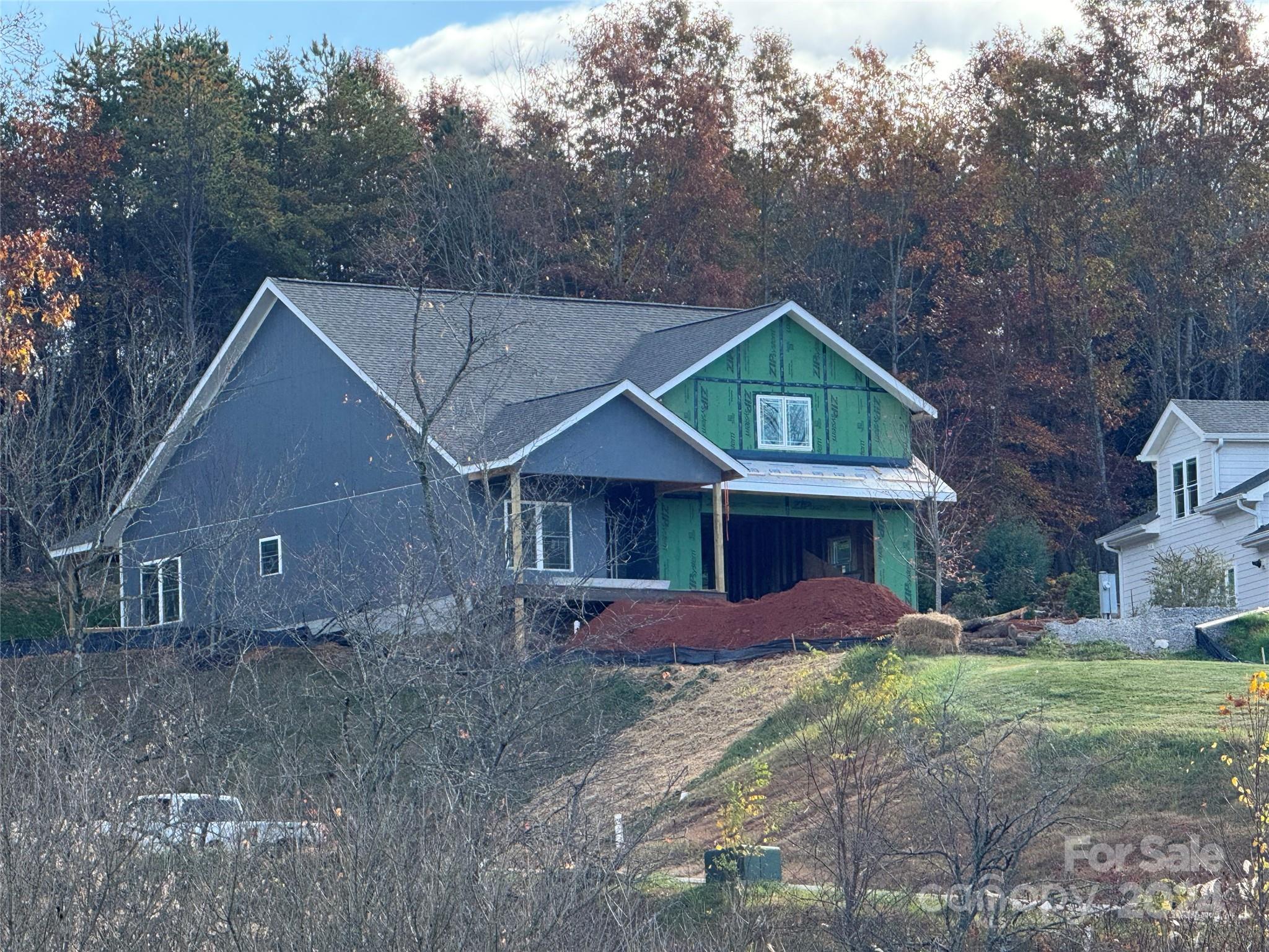 a front view of a house with a yard and large tree