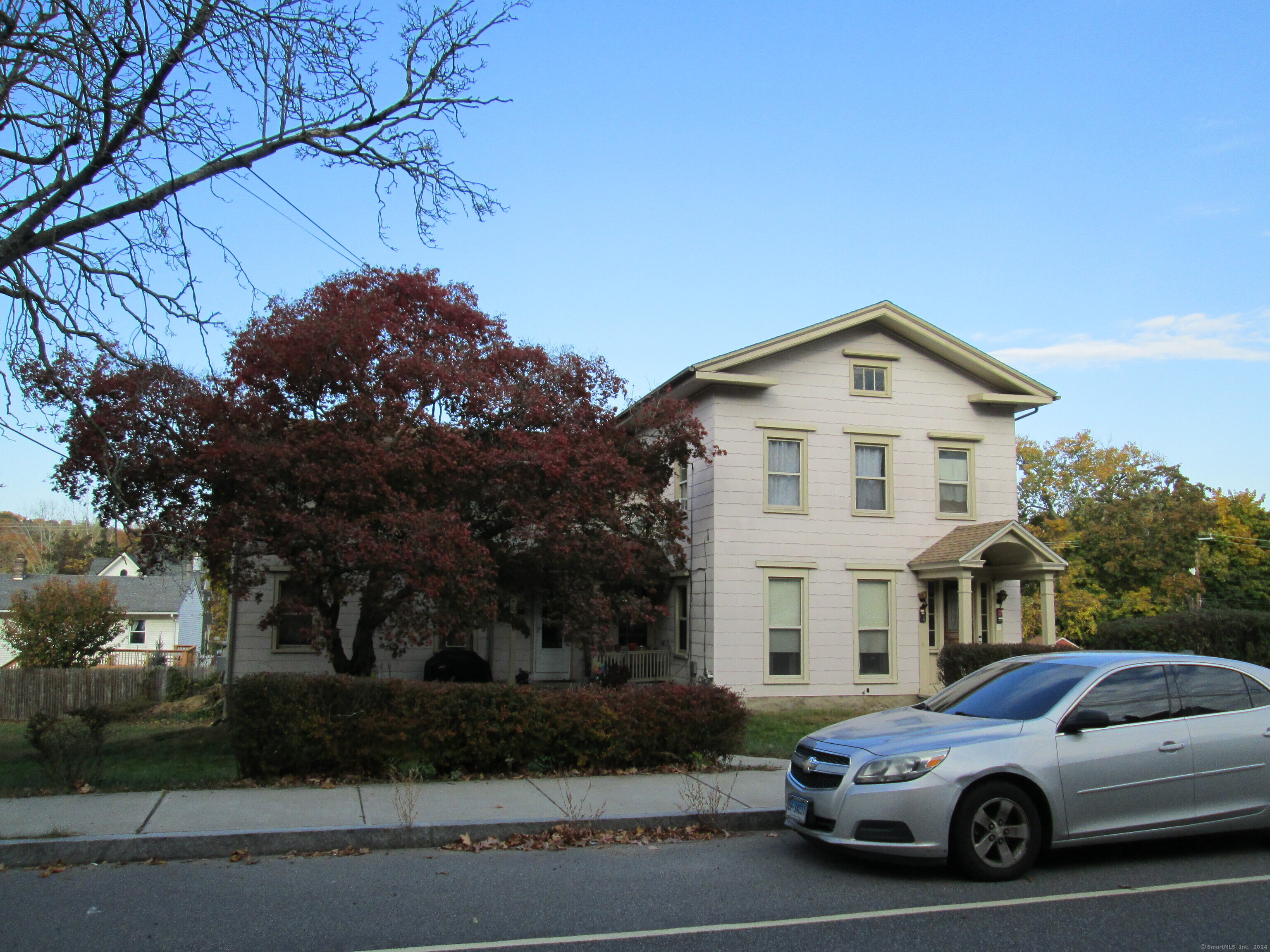 a view of a white house with a yard