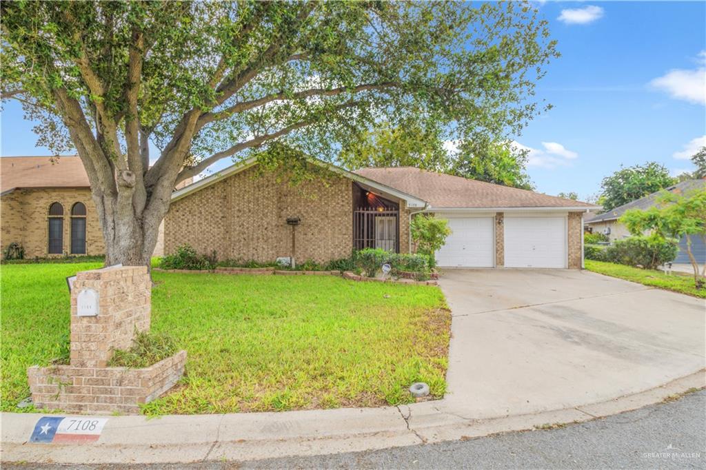 Single story home featuring a garage and a front lawn