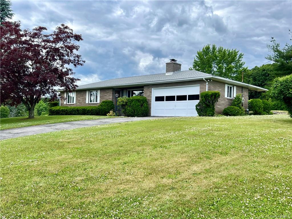 Single story home with a garage and a front yard