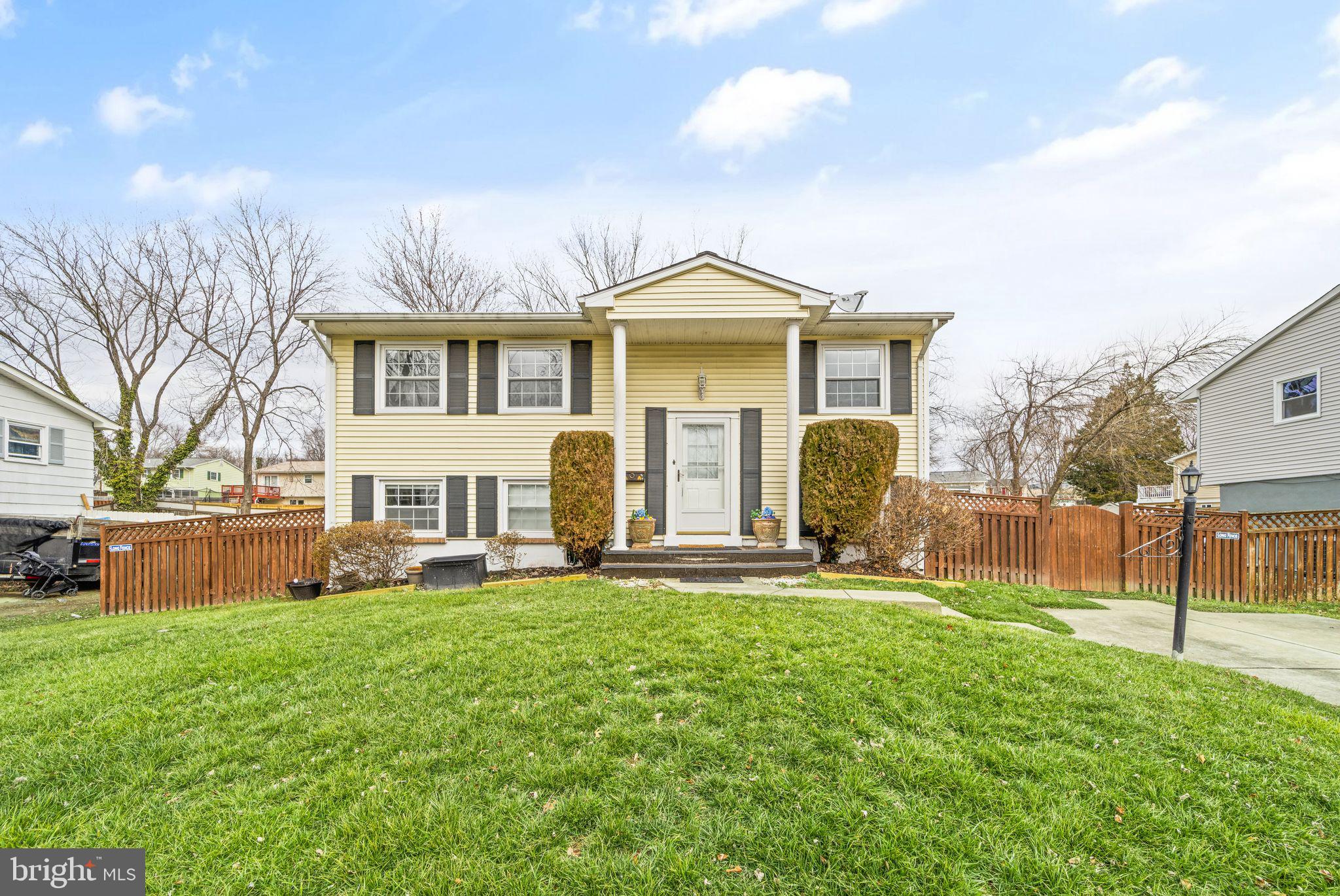 a front view of a house with a yard and trees