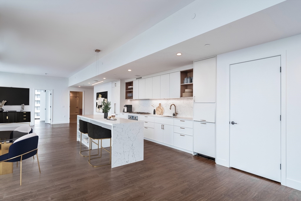 a kitchen with a sink and chairs