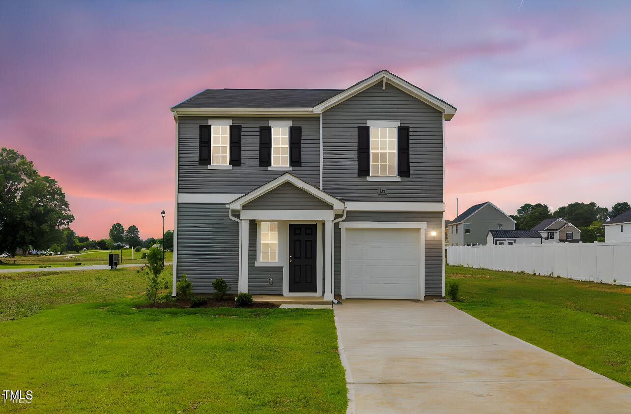 a front view of a house with a garden and yard