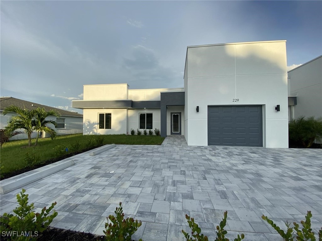 a front view of a house with a yard and a garage