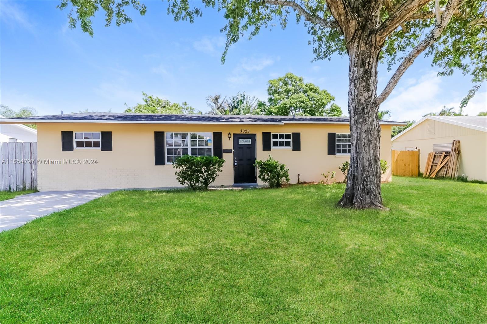 front view of house with a yard and an trees