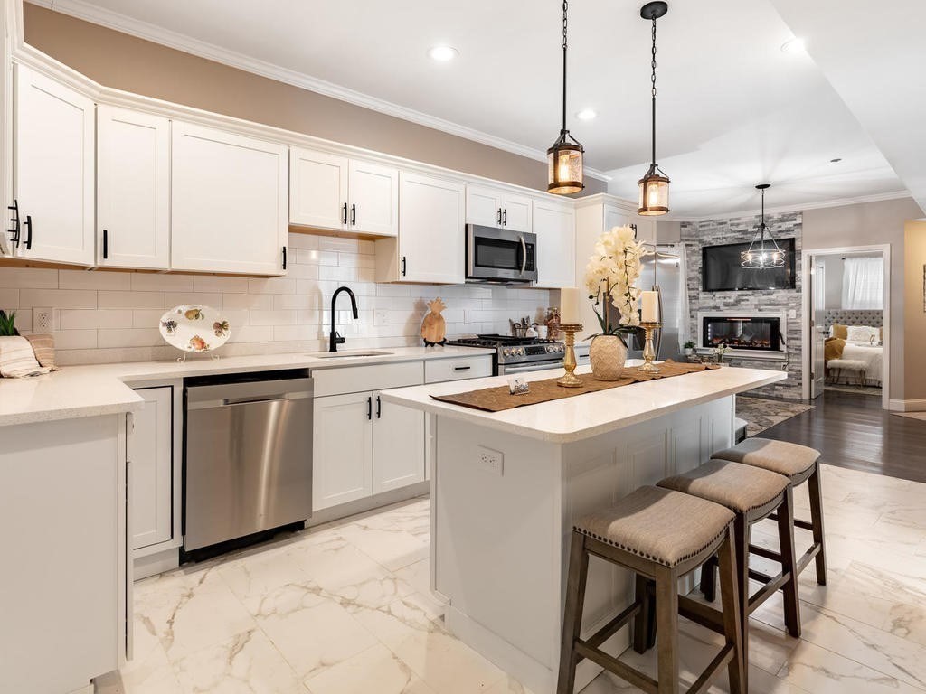 a kitchen with a sink a counter top space stainless steel appliances and cabinets