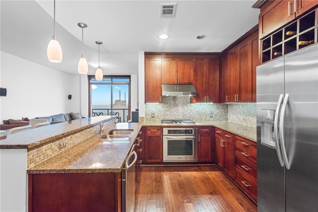 a kitchen with stainless steel appliances granite countertop a sink stove and refrigerator