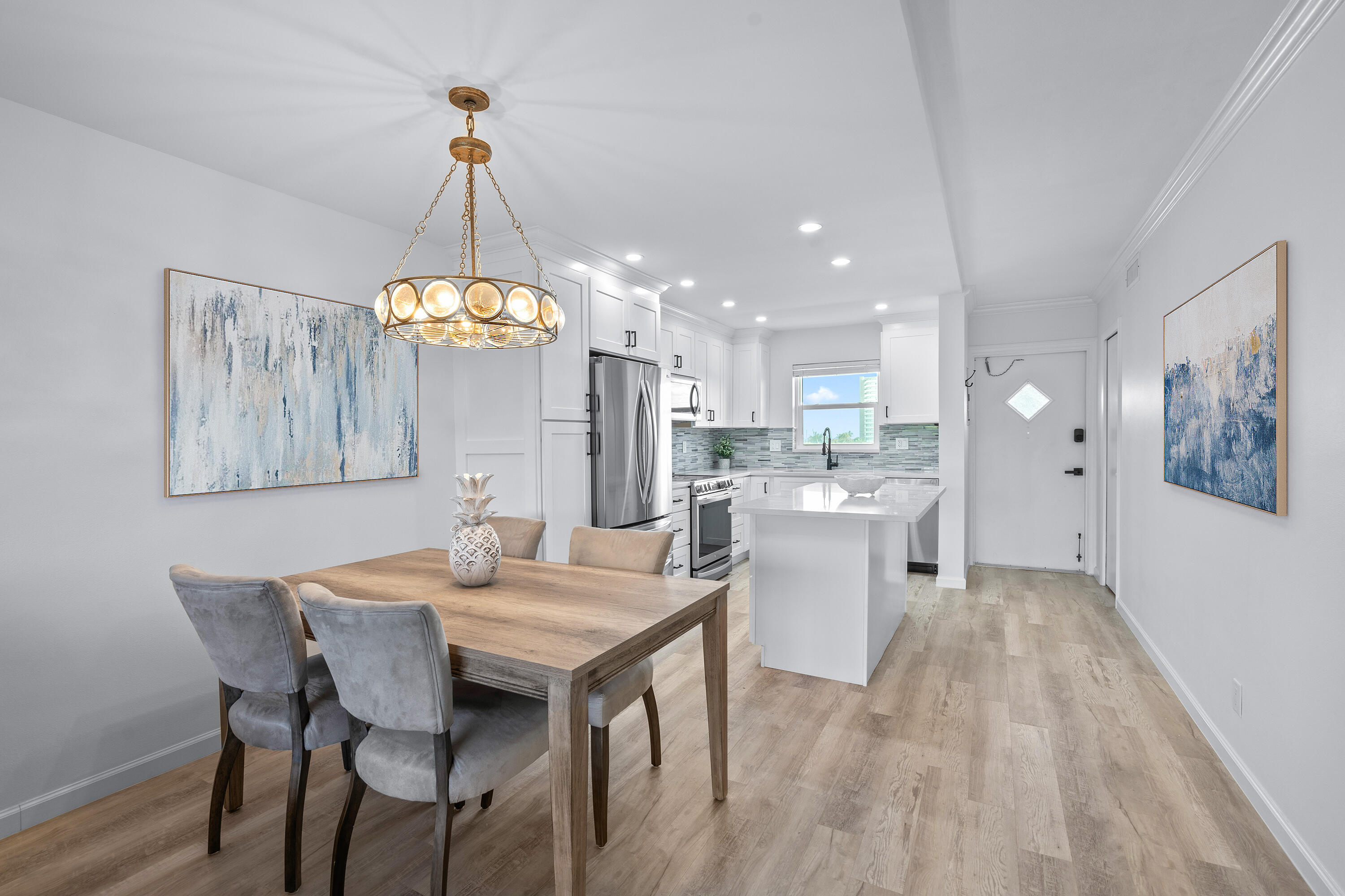 a kitchen with a dining table chairs and chandelier