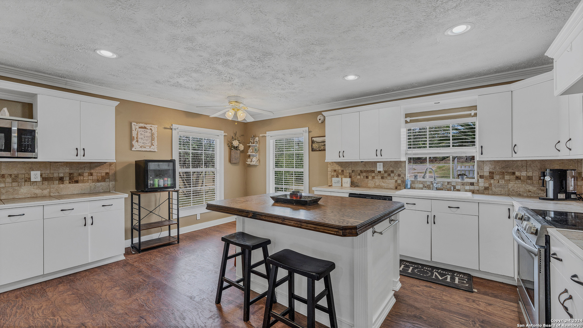 a kitchen with granite countertop white cabinets and white appliances