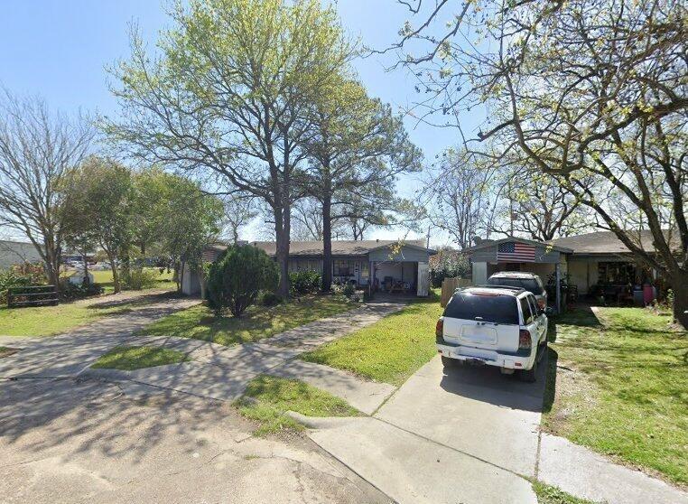 a view of a yard with furniture and trees in the background