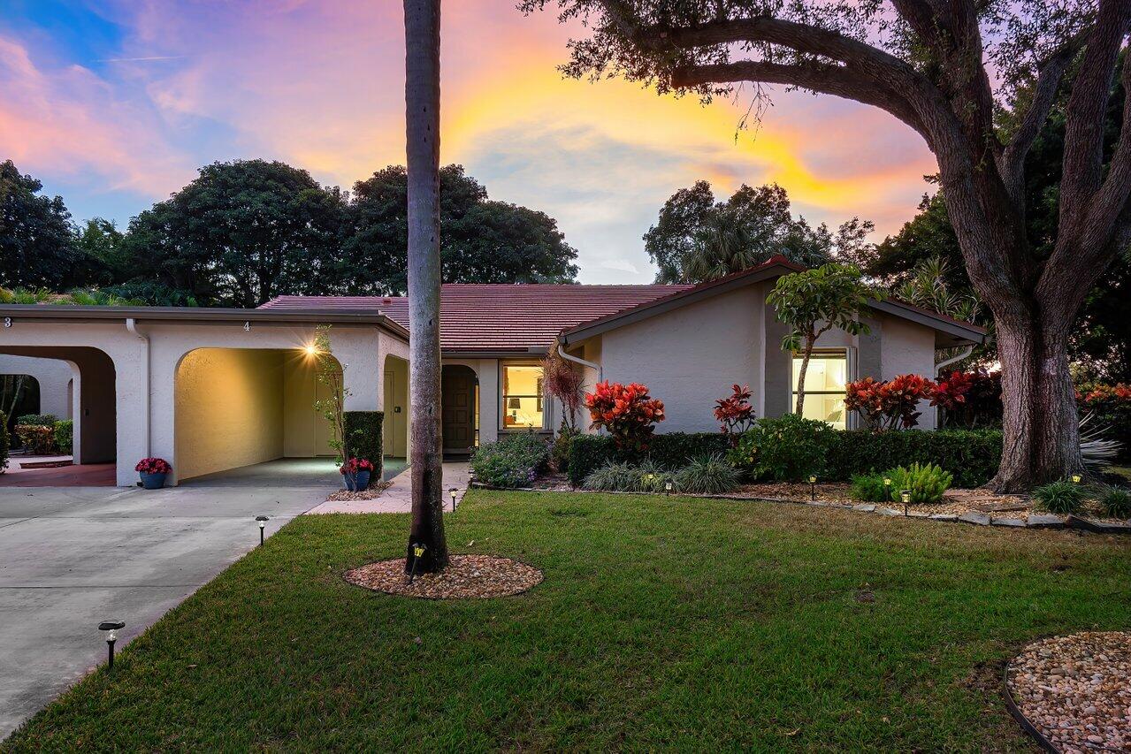 a front view of a house with garden and swimming pool