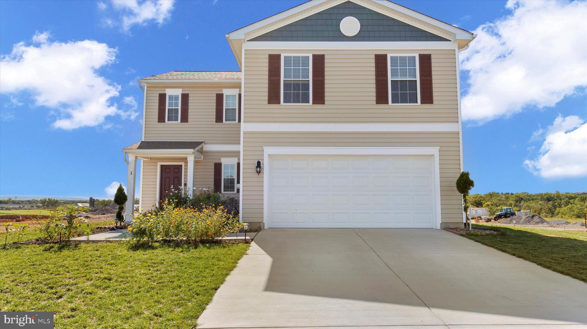 a front view of a house with a garden and yard