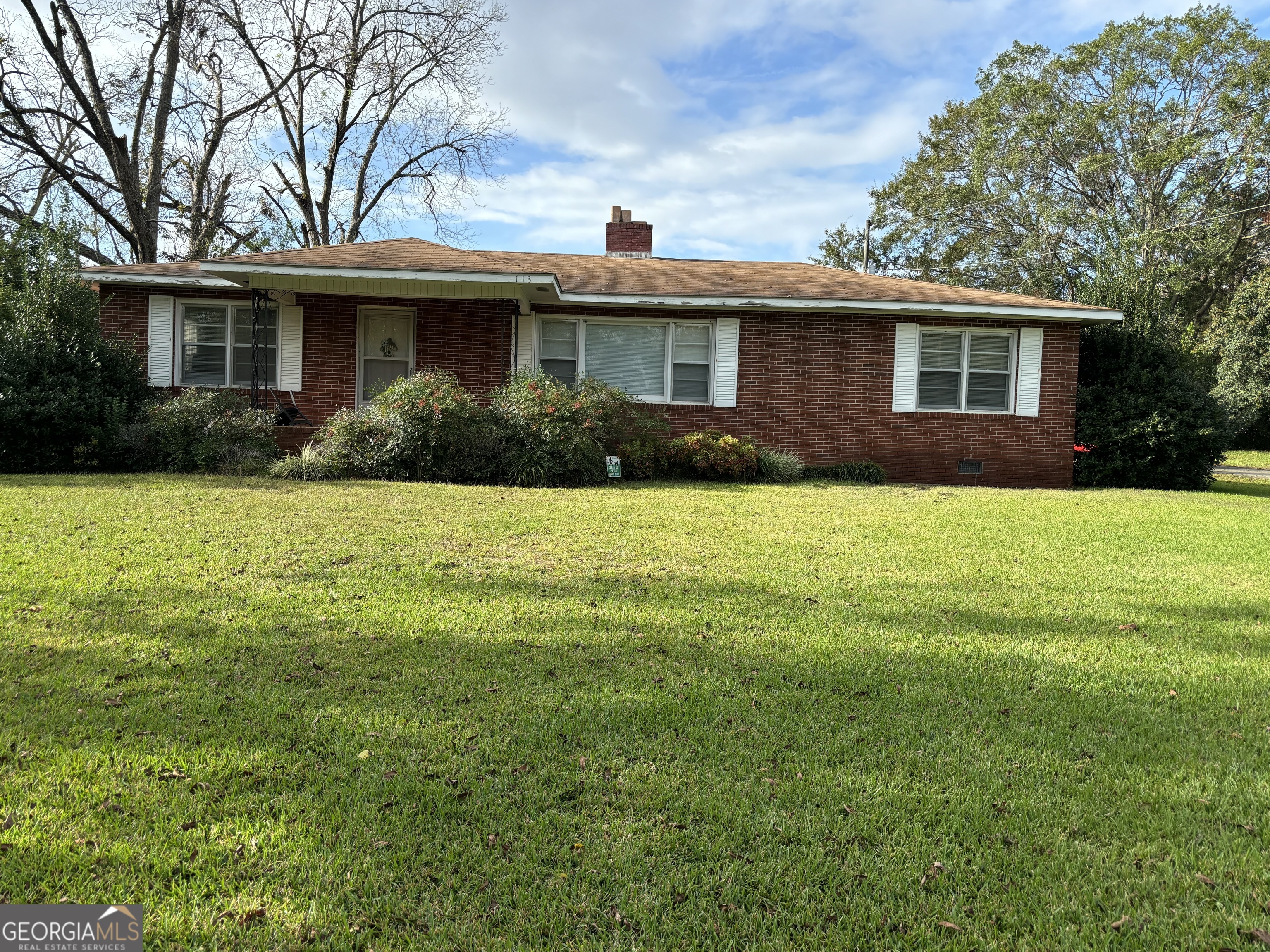 a front view of a house with yard and green space