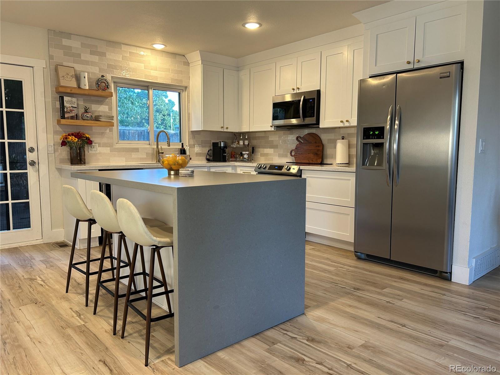 a kitchen with kitchen island a counter top space cabinets and stainless steel appliances