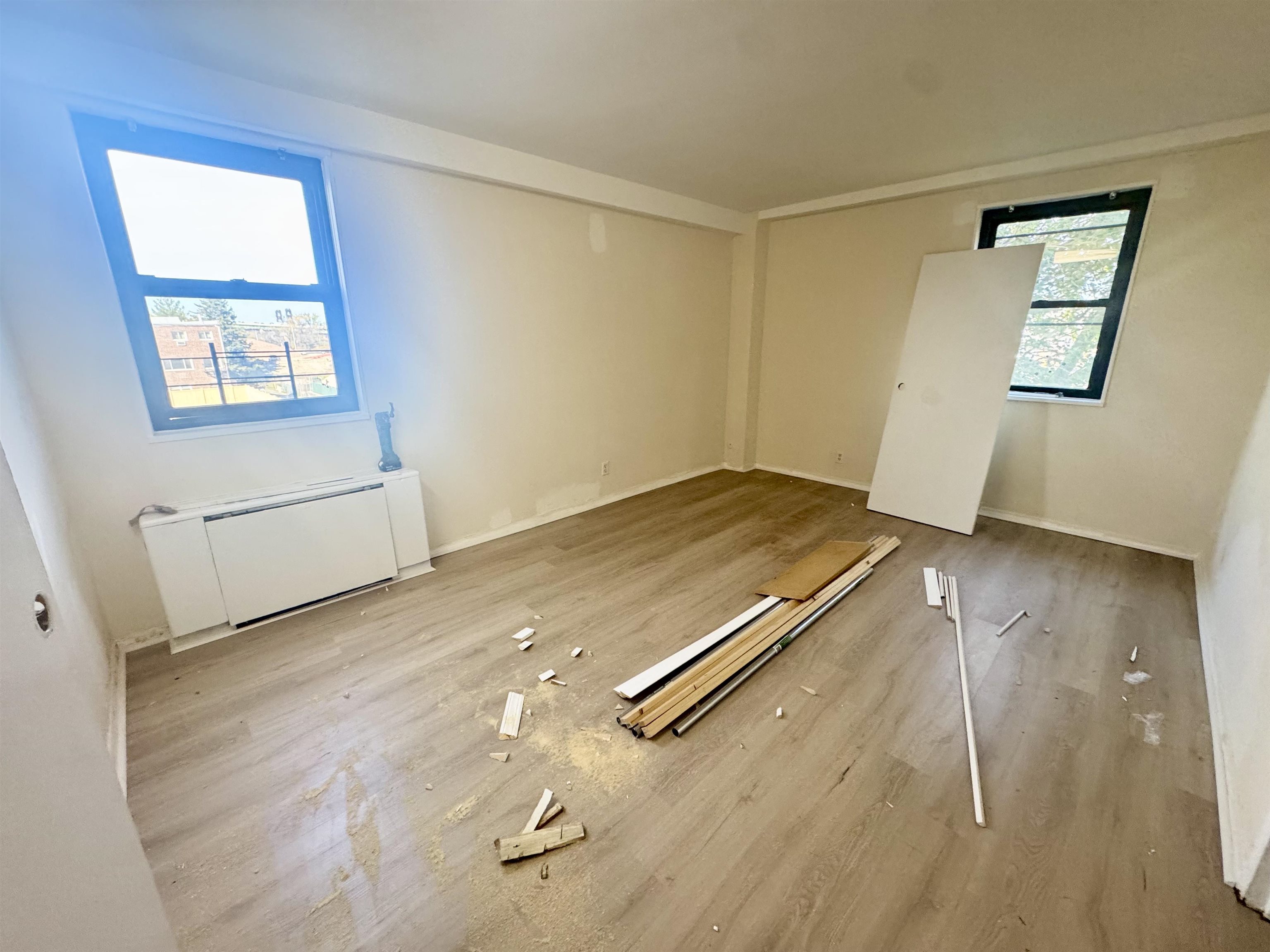 an empty room with wooden floor and windows