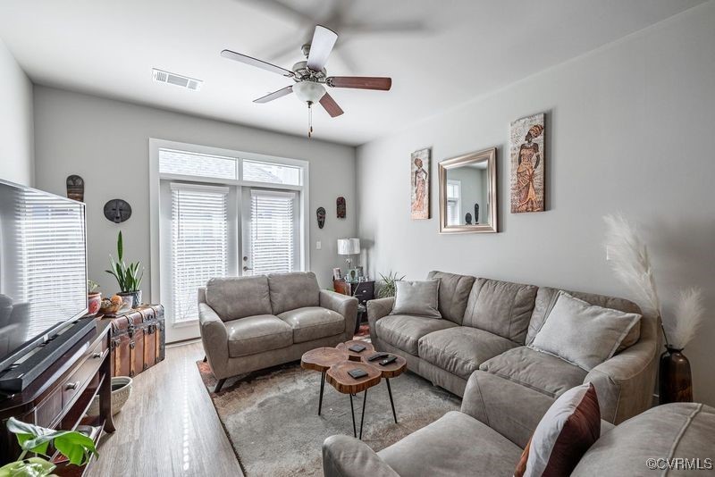 Living room featuring ceiling fan and light hardwo