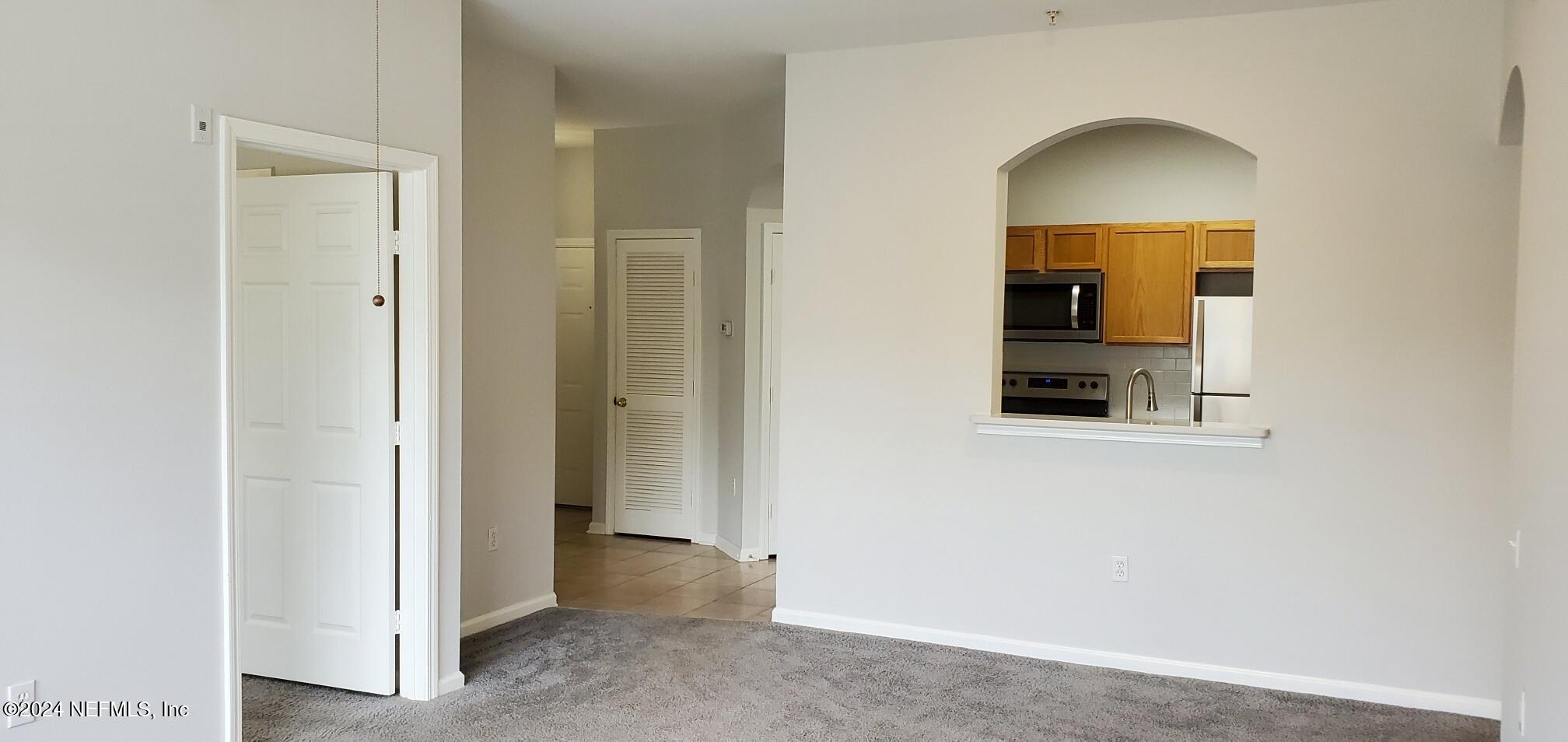 a view of a hallway with wooden floor and a living room