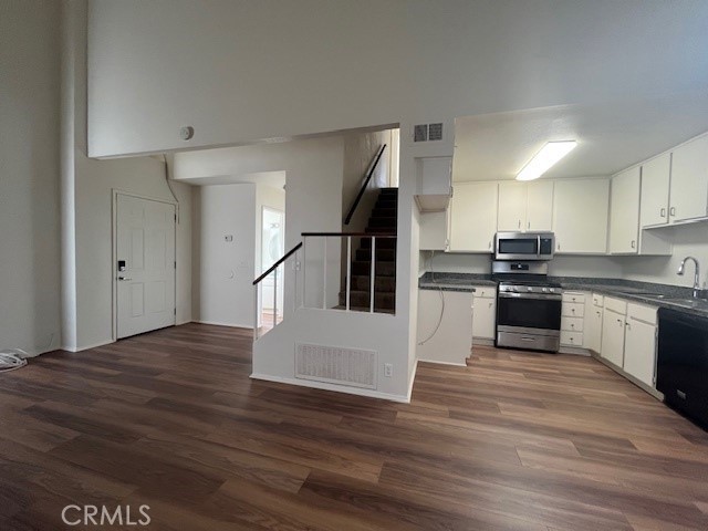 a kitchen with granite countertop a refrigerator and a stove top oven