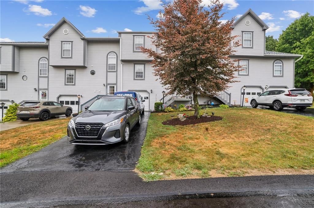 a front view of a house with cars parked